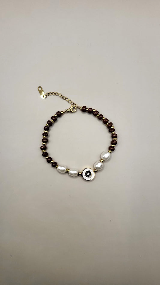 Bracelet with brown and white beads on a gray background